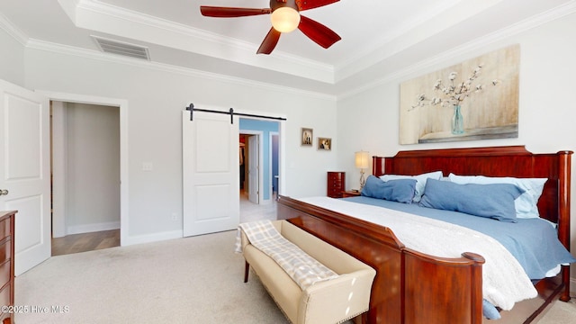 105 Camden Trl, Hampstead, NC 28443 - carpeted bedroom featuring a raised ceiling, a barn door, ornamental molding, baseboards, and ceiling fan
