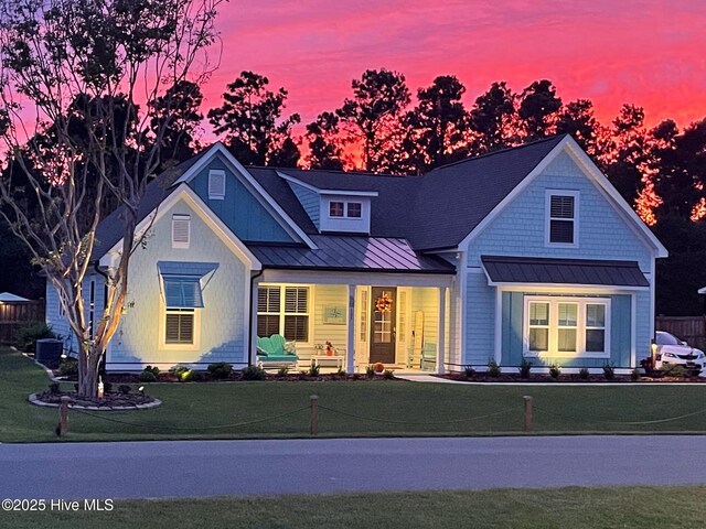 105 Camden Trl, Hampstead, NC 28443 - view of front facade featuring a standing seam roof, a porch, a yard, and metal roof