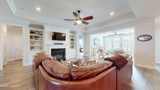 105 Camden Trl, Hampstead, NC 28443 - living area featuring ceiling fan, a glass covered fireplace, baseboards, light wood-type flooring, and ornamental molding
