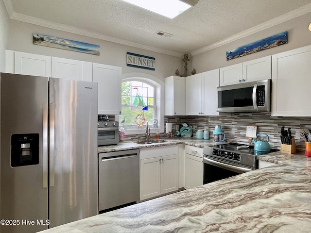 kitchen with crown molding, tasteful backsplash, light stone countertops, a sink, and stainless steel appliances
