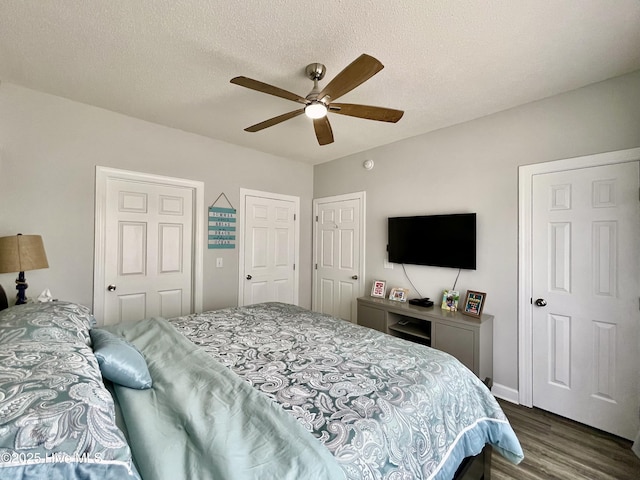 bedroom with dark wood-type flooring, a ceiling fan, and a textured ceiling