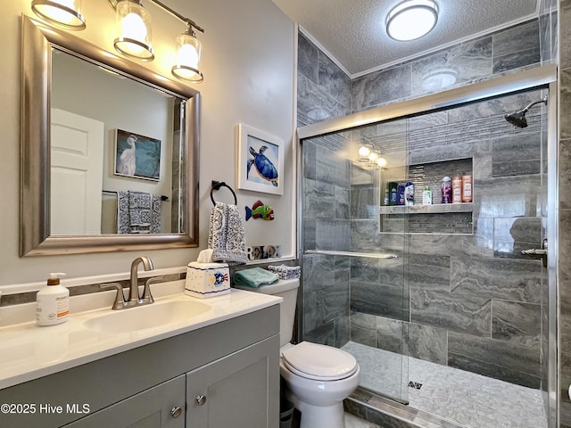 bathroom with vanity, a stall shower, toilet, and a textured ceiling