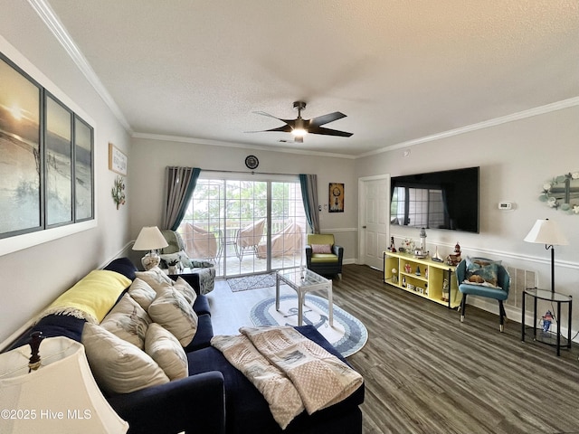 living room featuring a textured ceiling, ornamental molding, a ceiling fan, and wood finished floors