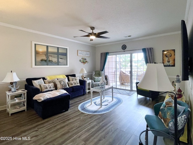 living room with visible vents, crown molding, dark wood finished floors, and ceiling fan