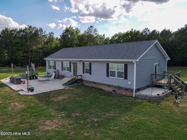 rear view of house with a lawn, a patio, a shingled roof, and crawl space