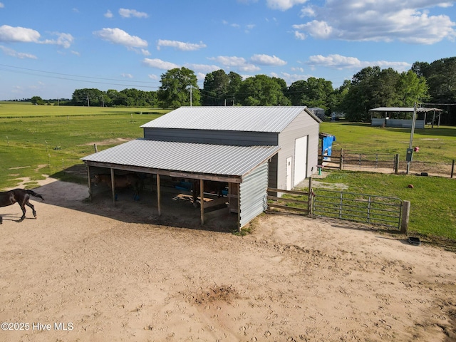 view of outbuilding featuring a rural view, an outdoor structure, a carport, and an exterior structure