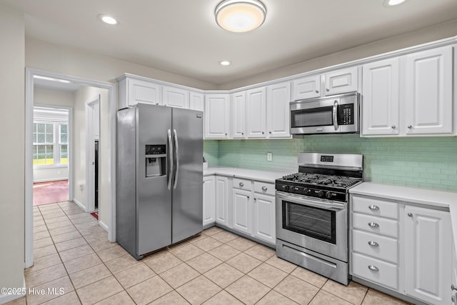 kitchen featuring stainless steel appliances, light countertops, light tile patterned flooring, and recessed lighting