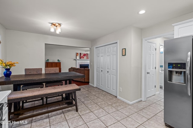dining area with light tile patterned flooring, a tile fireplace, recessed lighting, and baseboards