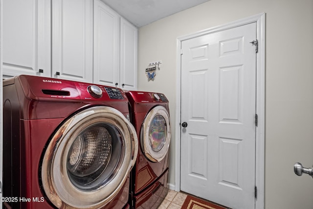 laundry room with washing machine and clothes dryer, cabinet space, and light tile patterned floors