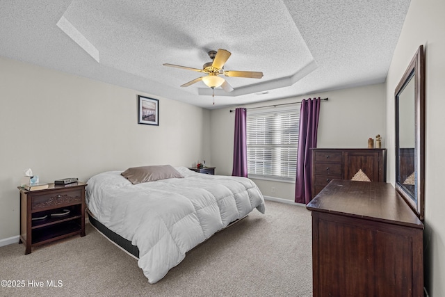 bedroom featuring a textured ceiling, light colored carpet, baseboards, and ceiling fan