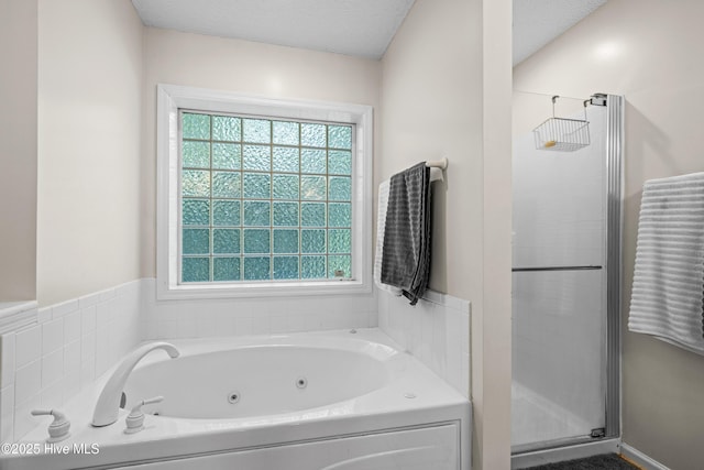 bathroom with a stall shower, healthy amount of natural light, and a tub with jets