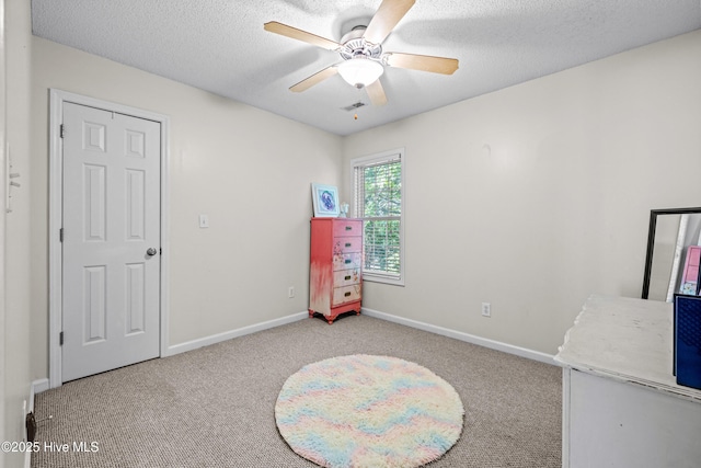 unfurnished bedroom with carpet flooring, baseboards, a textured ceiling, and ceiling fan