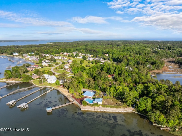 aerial view of property's location featuring a heavily wooded area and a nearby body of water