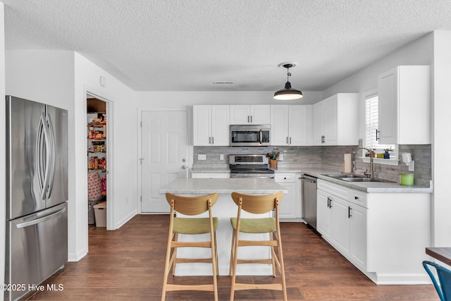 kitchen with a sink, white cabinetry, appliances with stainless steel finishes, and light countertops