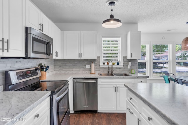 kitchen with dark wood-style floors, light countertops, a textured ceiling, a sink, and appliances with stainless steel finishes