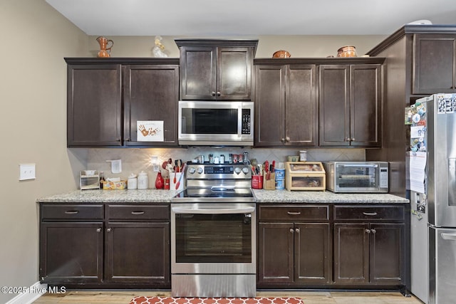 kitchen featuring backsplash, stainless steel appliances, and dark brown cabinets