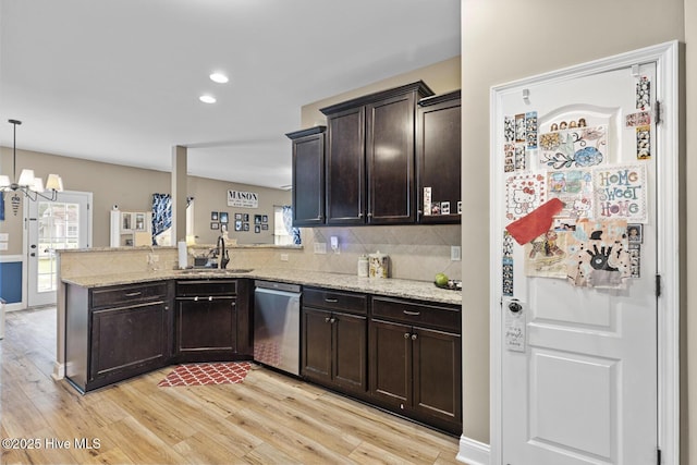 kitchen featuring stainless steel dishwasher, dark brown cabinets, a sink, a peninsula, and light wood-style floors
