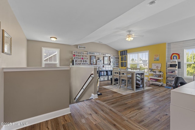 interior space featuring baseboards, a ceiling fan, dark wood-style flooring, and lofted ceiling