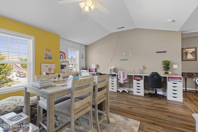 dining space with plenty of natural light, a ceiling fan, lofted ceiling, and wood finished floors