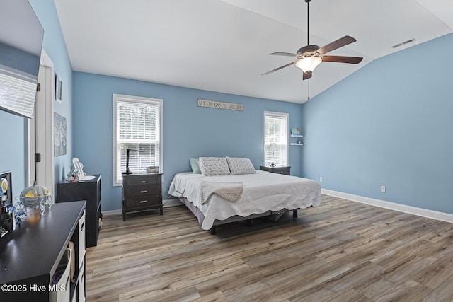 bedroom featuring multiple windows, vaulted ceiling, light wood-type flooring, and visible vents