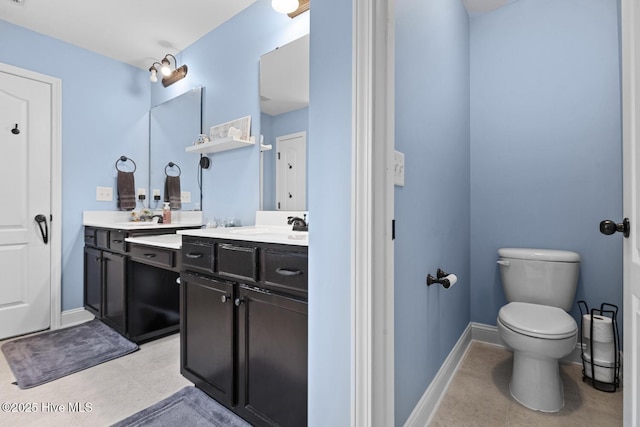 full bathroom featuring double vanity, baseboards, toilet, and a sink
