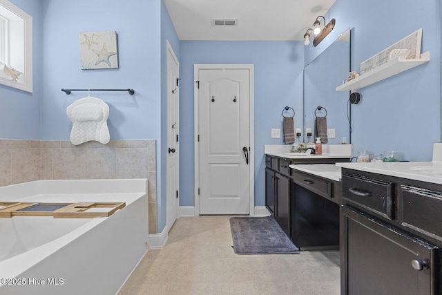 full bath featuring visible vents, a garden tub, and vanity