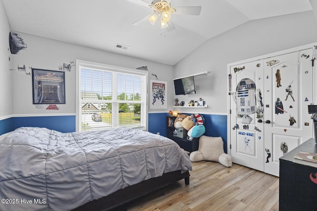 bedroom with visible vents, light wood-style floors, ceiling fan, and vaulted ceiling