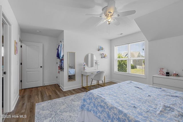 bedroom featuring baseboards, a ceiling fan, wood finished floors, and visible vents