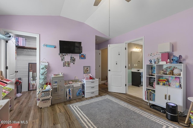 bedroom featuring connected bathroom, ceiling fan, wood finished floors, and lofted ceiling