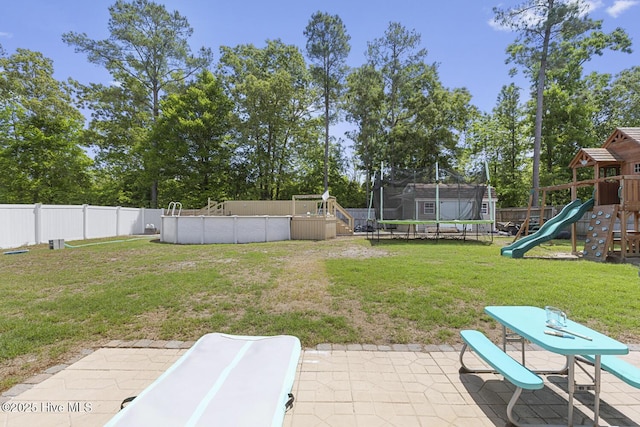 view of yard featuring a playground, a fenced in pool, a trampoline, and a fenced backyard