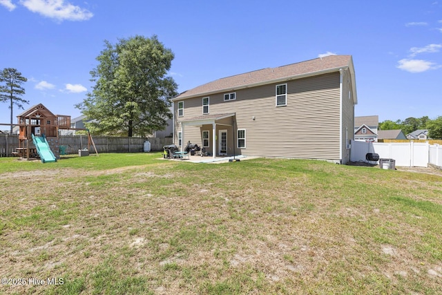 back of property with a playground, a patio, a lawn, and a fenced backyard