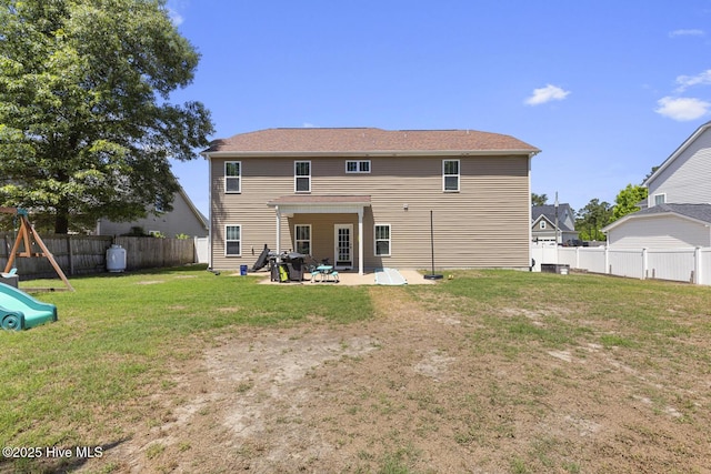 back of property featuring a playground, a fenced backyard, a yard, and a patio area