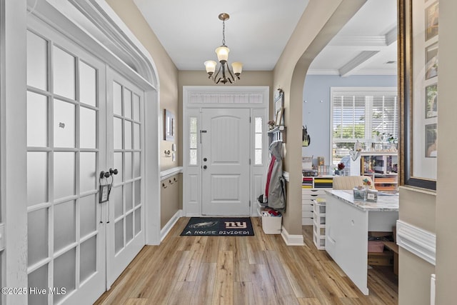 entryway with crown molding, an inviting chandelier, beam ceiling, light wood finished floors, and baseboards