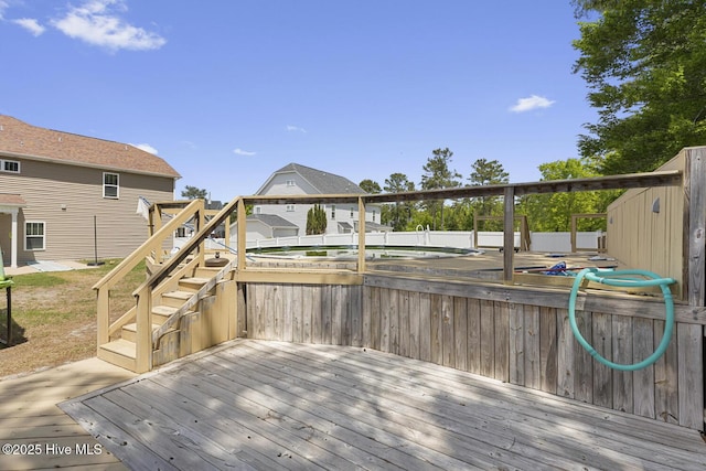 wooden terrace featuring fence and stairs
