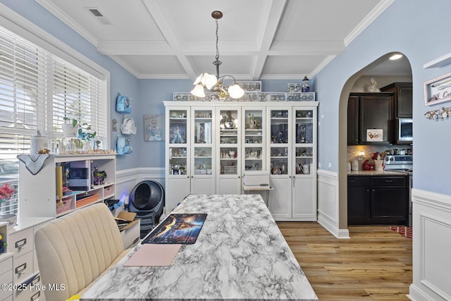 dining space featuring visible vents, beamed ceiling, a chandelier, arched walkways, and light wood finished floors