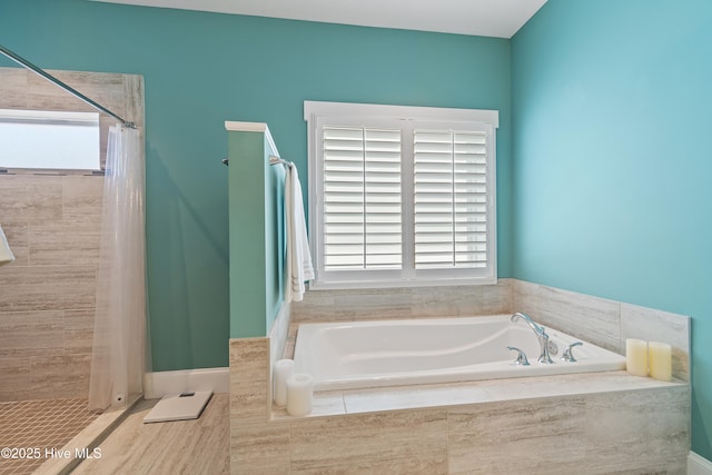 bathroom featuring tiled shower and a bath