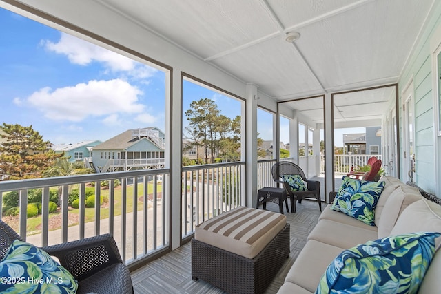 sunroom / solarium featuring an outdoor living space, a residential view, and plenty of natural light