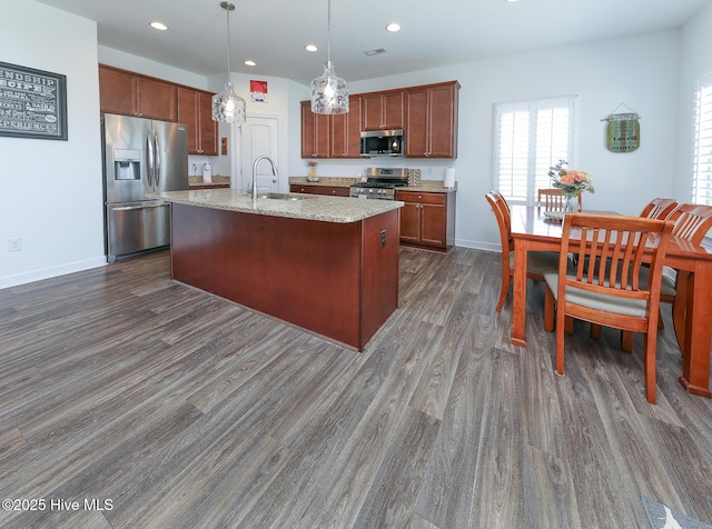 kitchen with stainless steel appliances, a sink, dark wood-style flooring, recessed lighting, and pendant lighting
