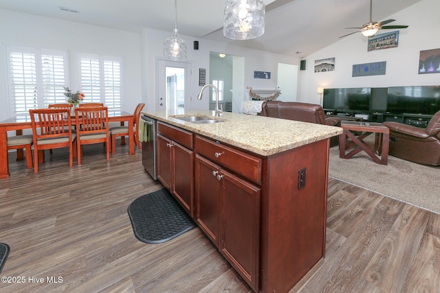 kitchen featuring a sink, dishwasher, wood finished floors, open floor plan, and lofted ceiling