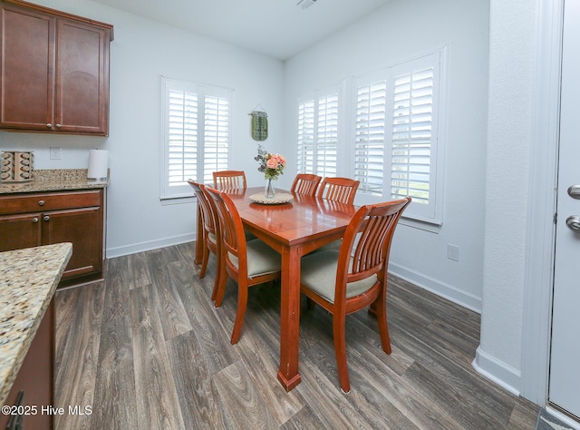 dining area featuring dark wood-style flooring and baseboards