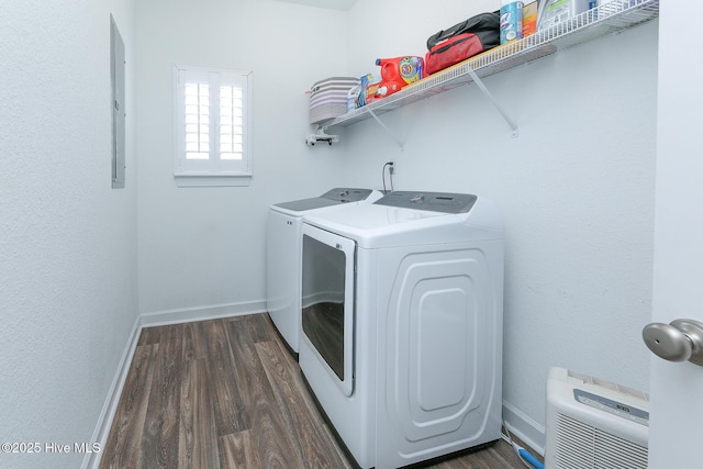 laundry area featuring washing machine and clothes dryer, baseboards, dark wood-type flooring, electric panel, and heating unit