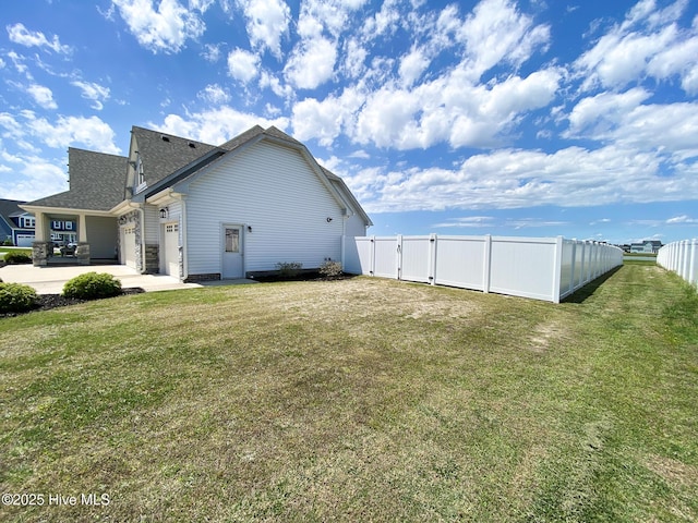 view of property exterior with a gate, a patio, a shingled roof, and an attached garage