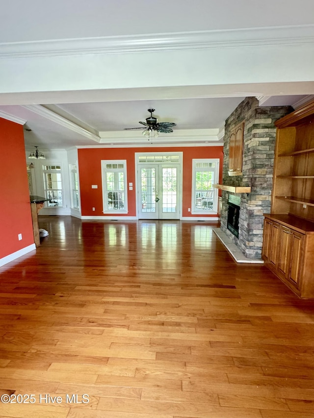 117 Quail Woods Dr, New Bern, NC 28560 - unfurnished living room with crown molding, baseboards, a stone fireplace, and light wood-type flooring