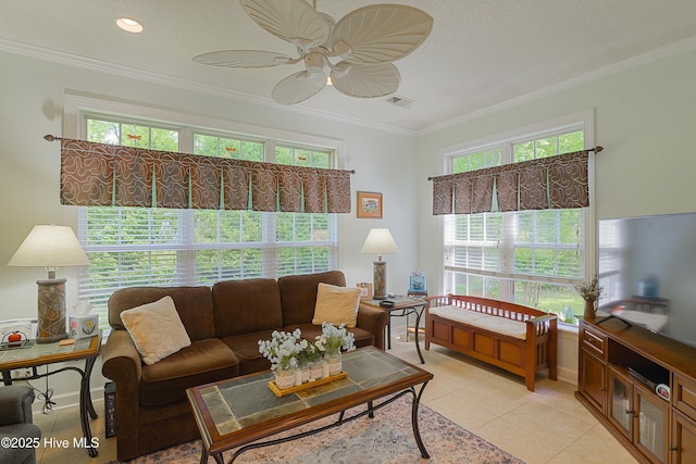 living room with crown molding, plenty of natural light, a ceiling fan, and visible vents