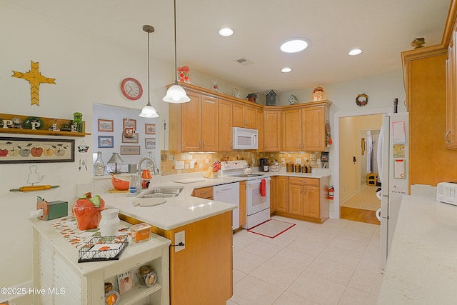 kitchen with white appliances, a sink, a peninsula, backsplash, and light countertops