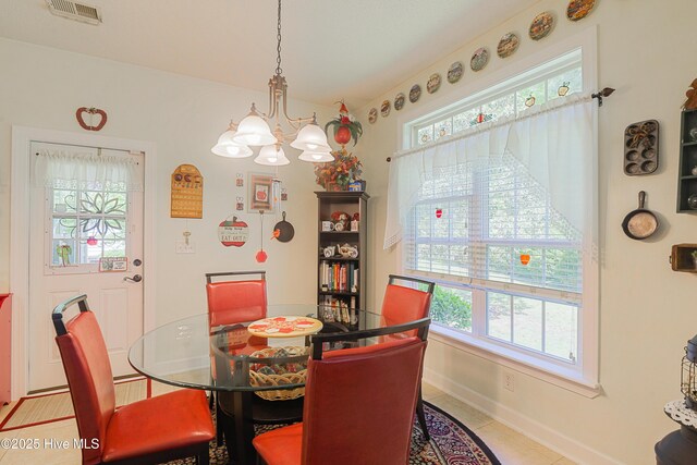 dining space featuring baseboards, tile patterned floors, a chandelier, and visible vents
