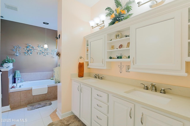 bathroom with tile patterned flooring, a garden tub, visible vents, and a sink