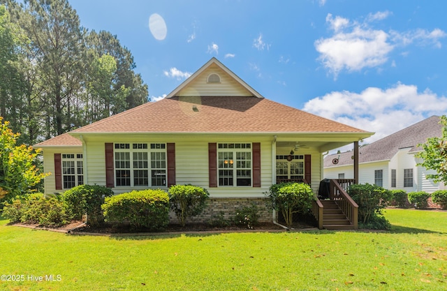 view of front of house featuring stairway, ceiling fan, roof with shingles, and a front yard