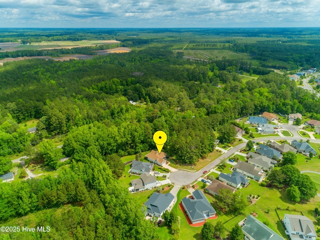 drone / aerial view featuring a wooded view and a residential view