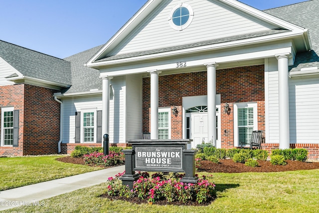community / neighborhood sign featuring a garage and a lawn